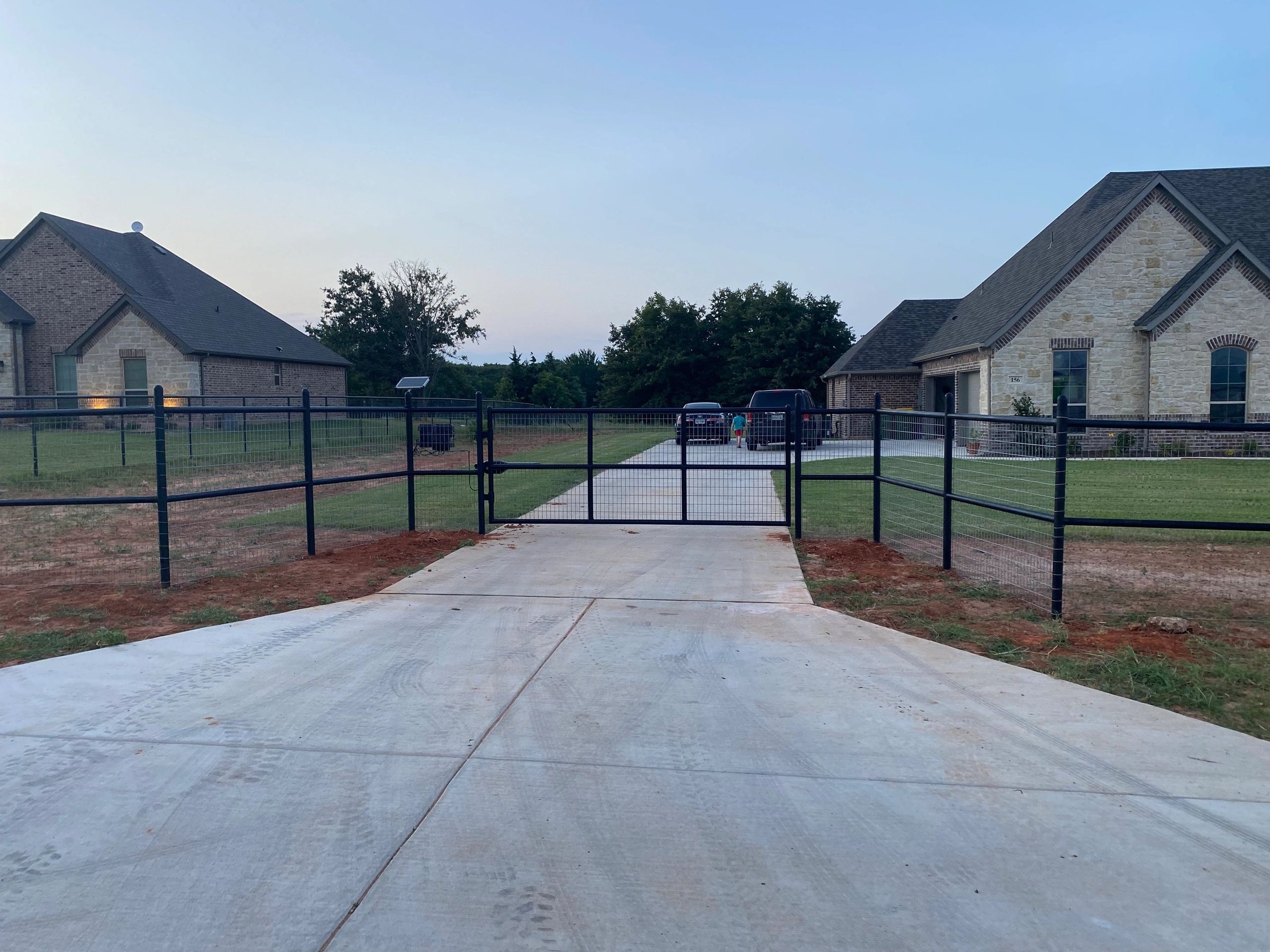 Estate drive with black pipe fence